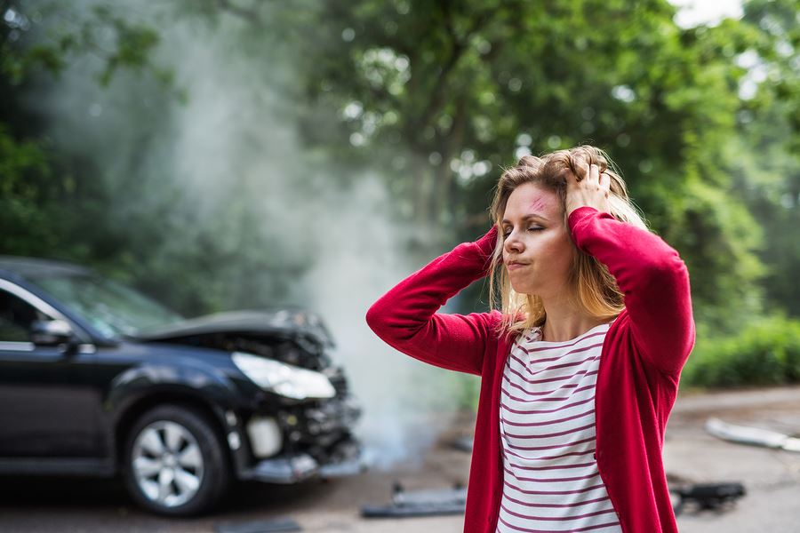 woman in car crash standing outside with her hands on her head